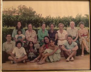 Gilberto Saboia, sentado no chão, primeiro da esquerda para a direita, posa para foto junto a integrantes da sua família e da família de sua esposa, Maria Helena, sentada à sua direita, com a filha Ana no seu colo. Sentados no chão, à direita de Gilberto Saboia e logo abaixo de Ana, estão os outros dois filhos do casal: Eduardo e Isabel.